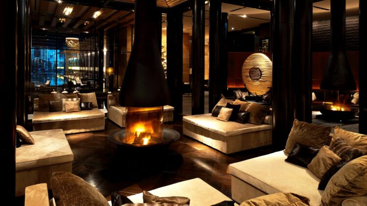 hotels in heaven chedi andermatt CAM Dining The Lobby fireplace bell lounge couch black chimney dark room