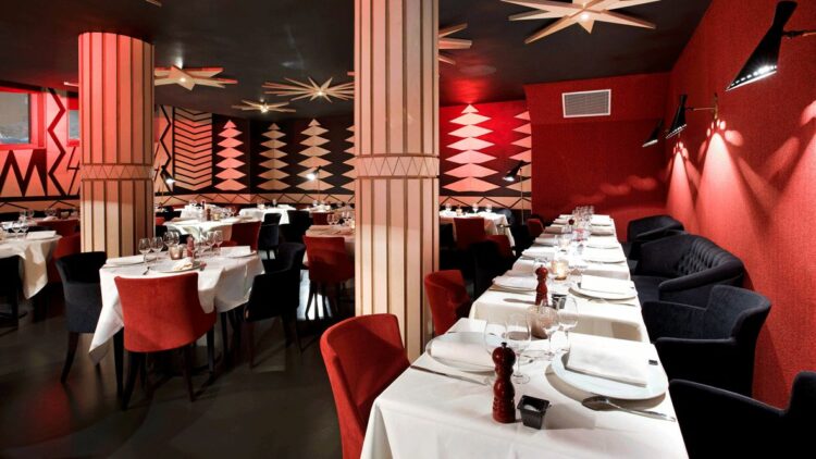 hotels in heaven altapura val thorens culinary restaurant red walls linen tables plates forks knives columns lights