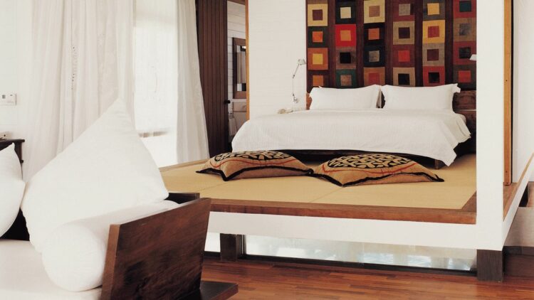 hotels in heaven como cocoa island room indoor bed big white linens red brown yellowish cushions wooden floor sofa