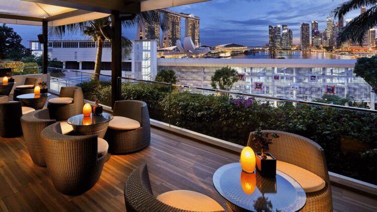 hotels in heaven mandarin oriental singapore terrasse culinary view armchairs lamps table skyline skyscapers