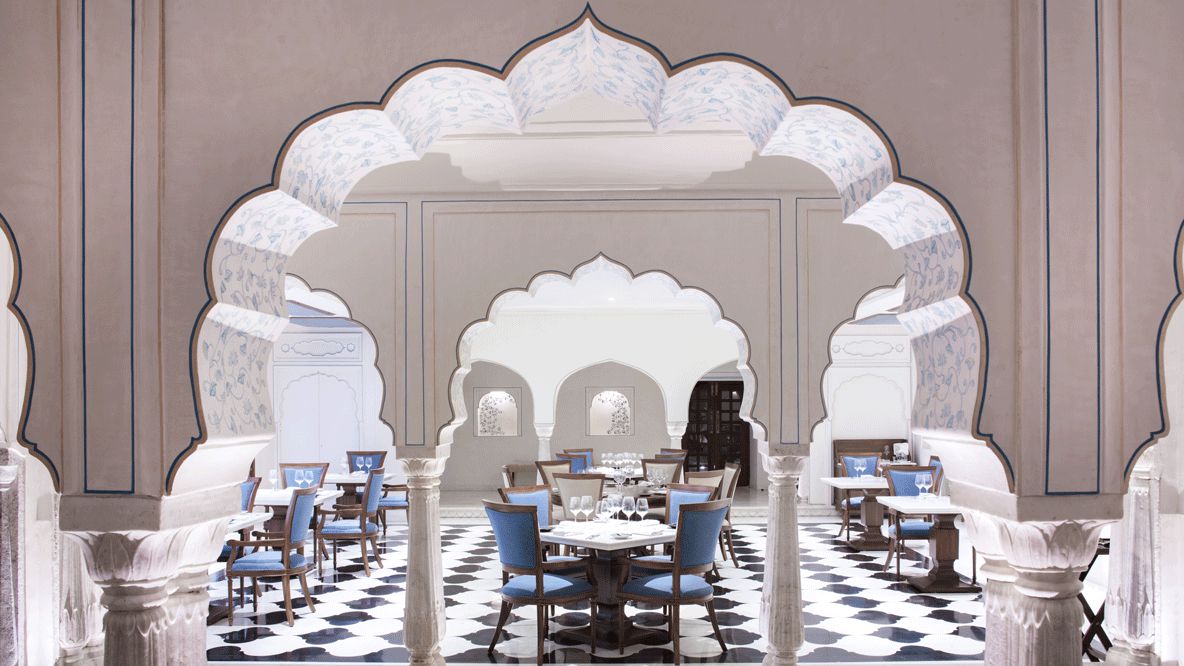 hotels in heaven Alila Fort Bishangarh restaurant food culinary inside luxury hotel dinner blue white chair table dishes wine glass door beautiful noble
