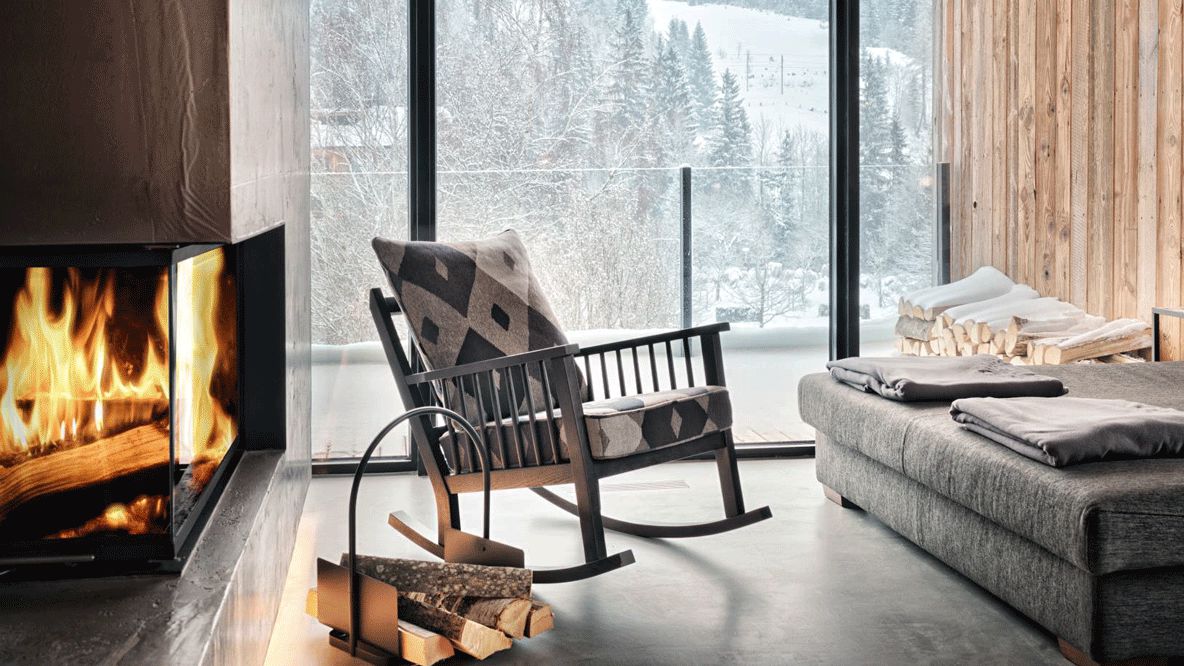 hotels in heaven hotel forsthofgut room fireplace wood fire romantic cozy warm view window rocking chair pillow couch lake wood balcony tree snow luxury Austria