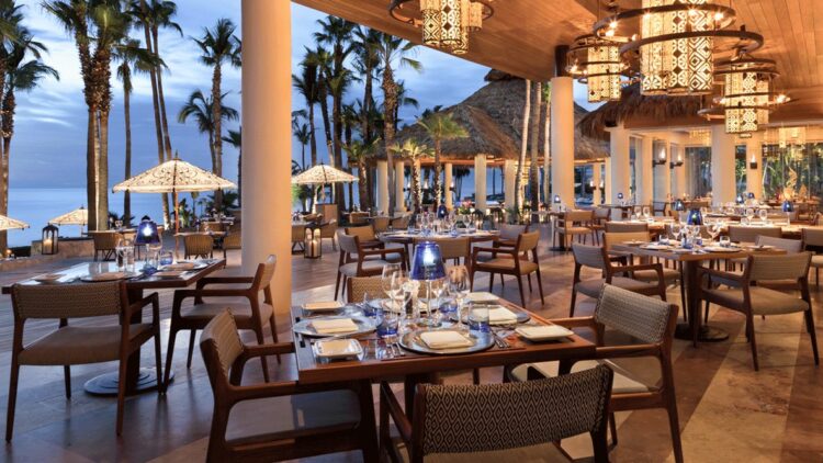 hotels in heaven one and only palmilla culinary restaurant dining dinner luxury hotel palm trees dishes napkin sea sunshades lights romantic