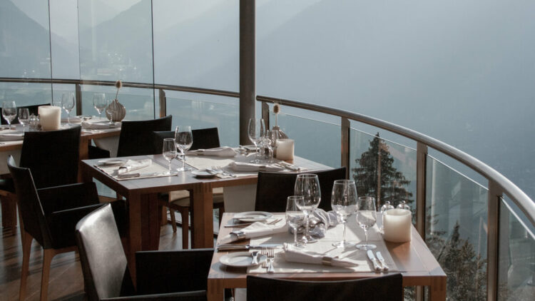 hotels in heaven miramonti boutique panorama restaurant view foggy day chairs table glasses wine candles napkins vase balcony