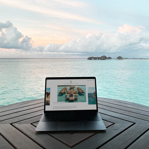 Laptop on a table by the ocean